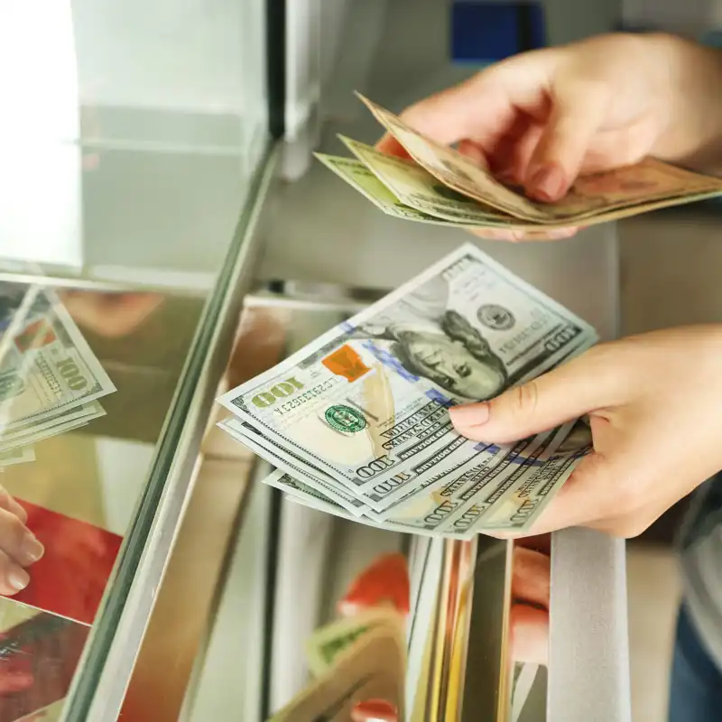 Female hand with money in cash department window.