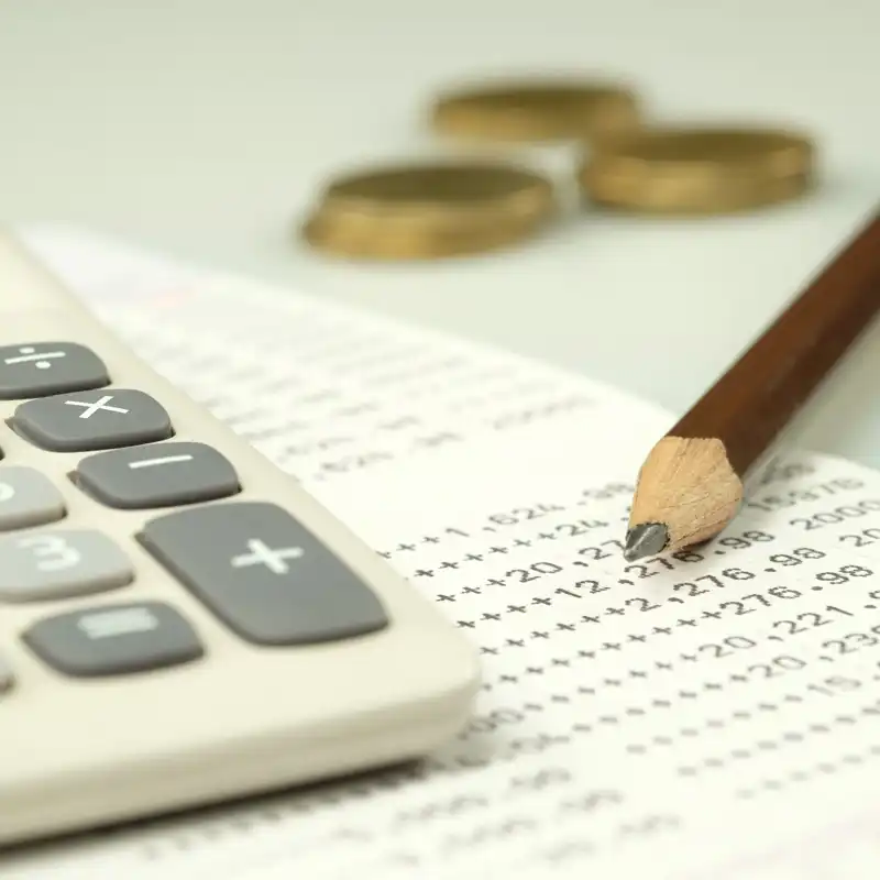 Close up of a bank statement, calculator and pencil.
