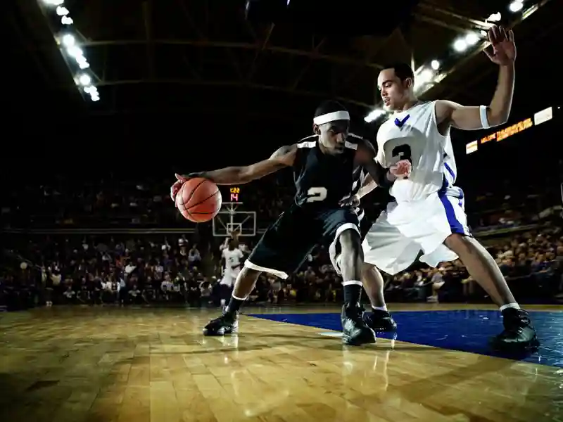 Basketball player being guarded by defender.