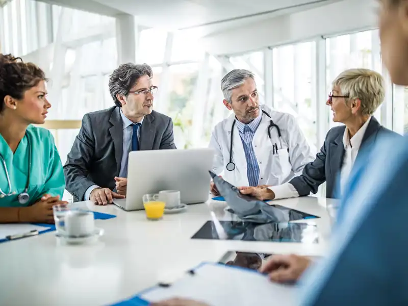 Group of medical professional sitting around a table talking