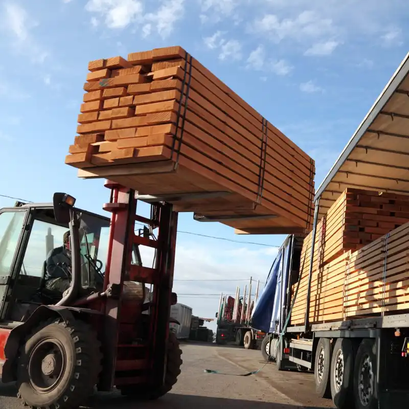 Fork lift placing lumber onto a truck.