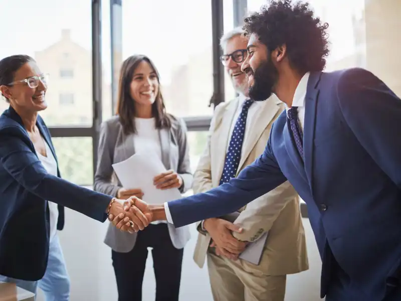 Coworkers shaking hands during a business meeting.