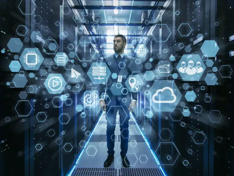 Curios IT engineer standing in the middle of a working data center server room.