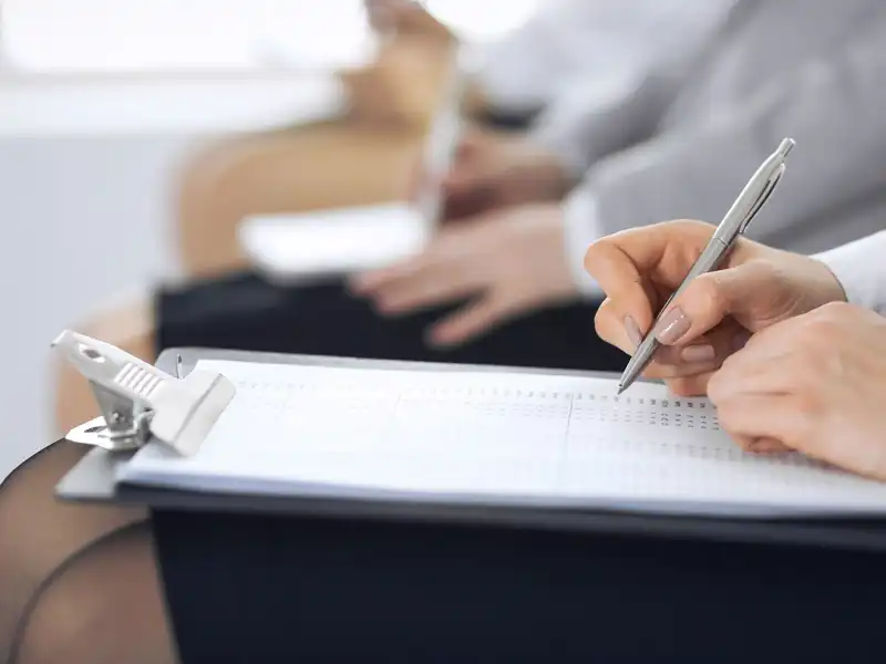 Women sitting on chairs and making notes meeting