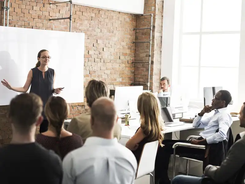 Business meeting in a conference room with a white board.