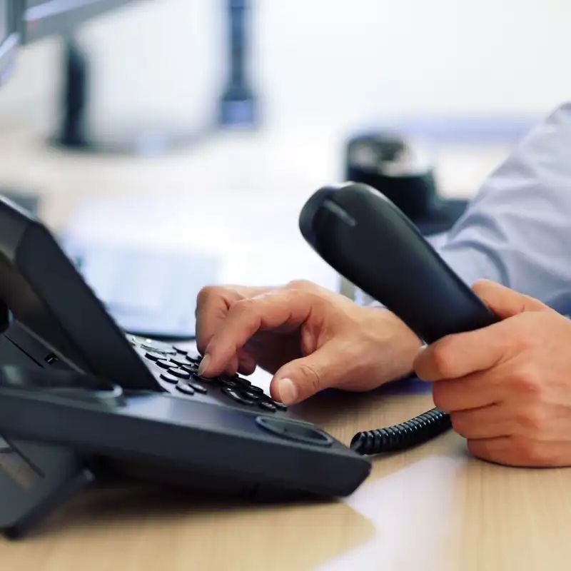 Close up of a businessman dialing a telephone.
