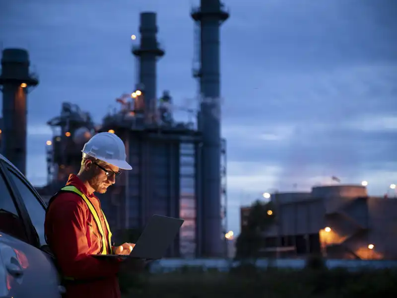 construction worker looking at laptop in the early morning