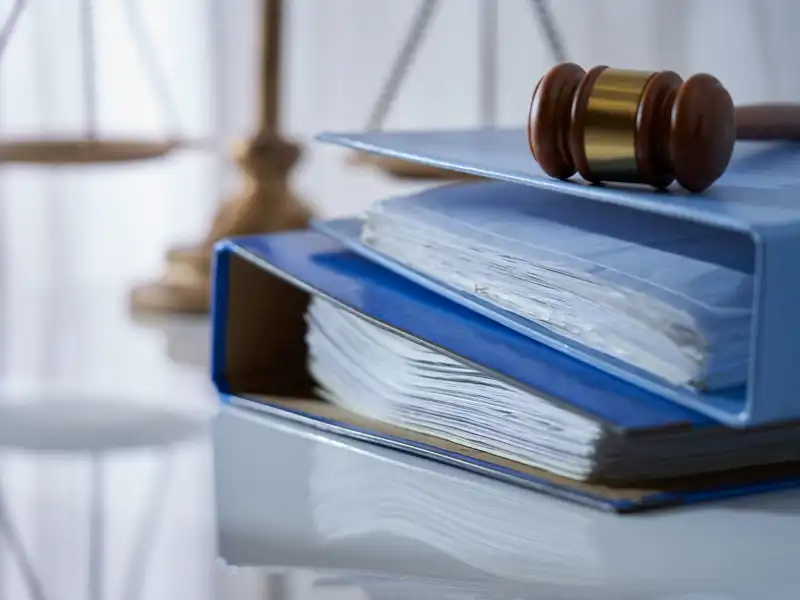 Close up of a gavel on multiple binders of paper