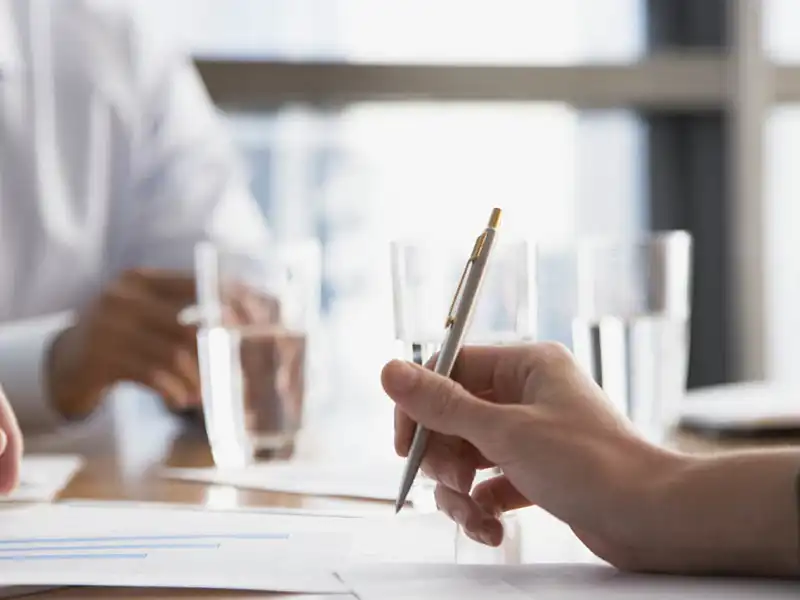 Person holding a silver pen.