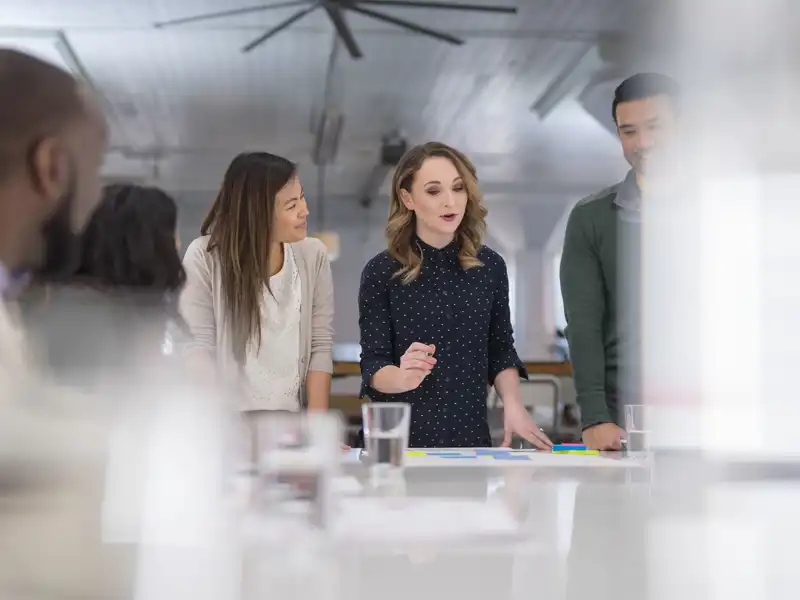 Business people listening to coworker speak at a table.