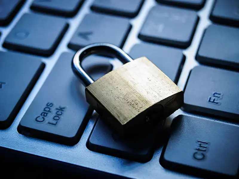 A small padlock sits atop a computer keyboard.