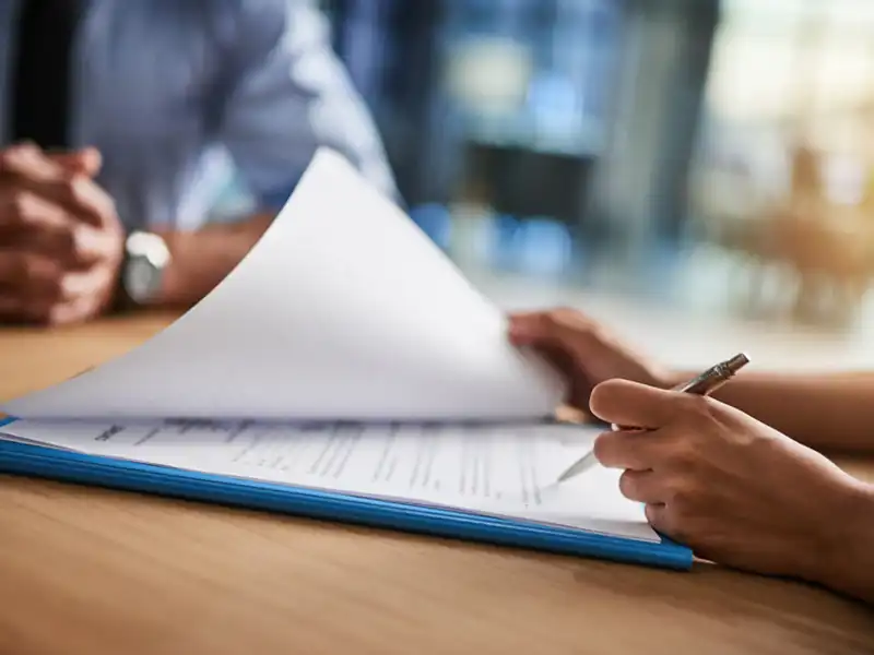 Two people looking over a document while seated at a table.