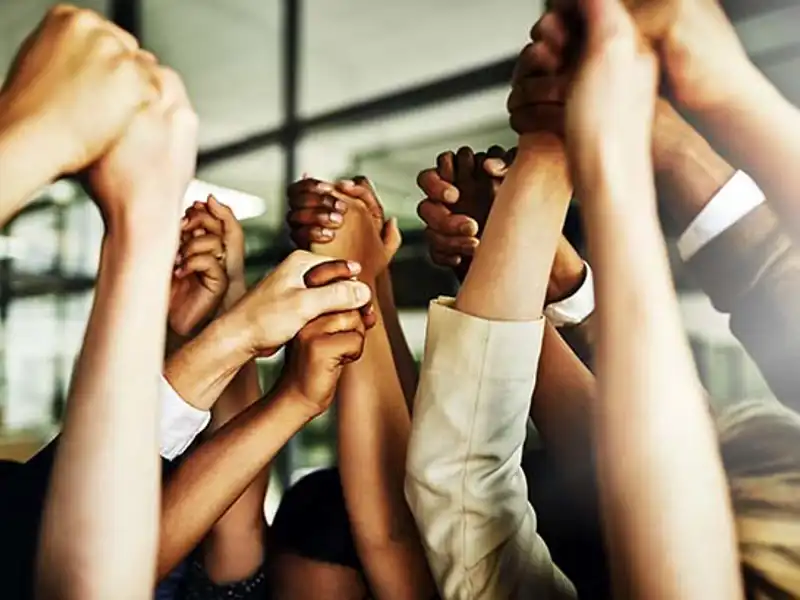 Joined hands held up in the air