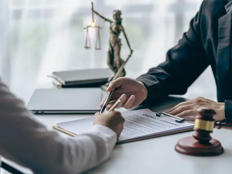 Professional showing a client paperwork over a desk.