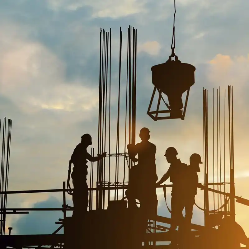 construction workers on a building at sunrise