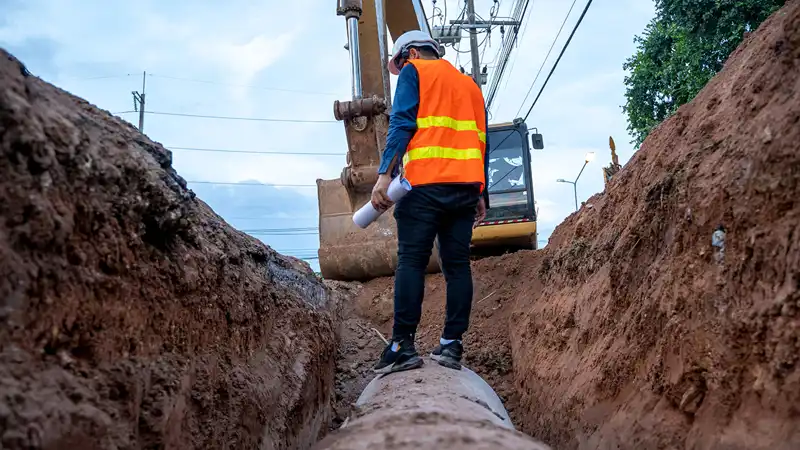 A construction worker looking over a digging site.