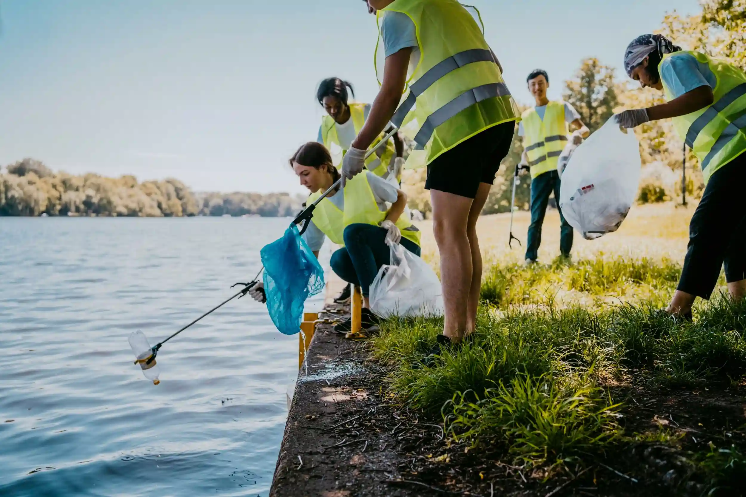 Volunteers picking trash out of a lake.