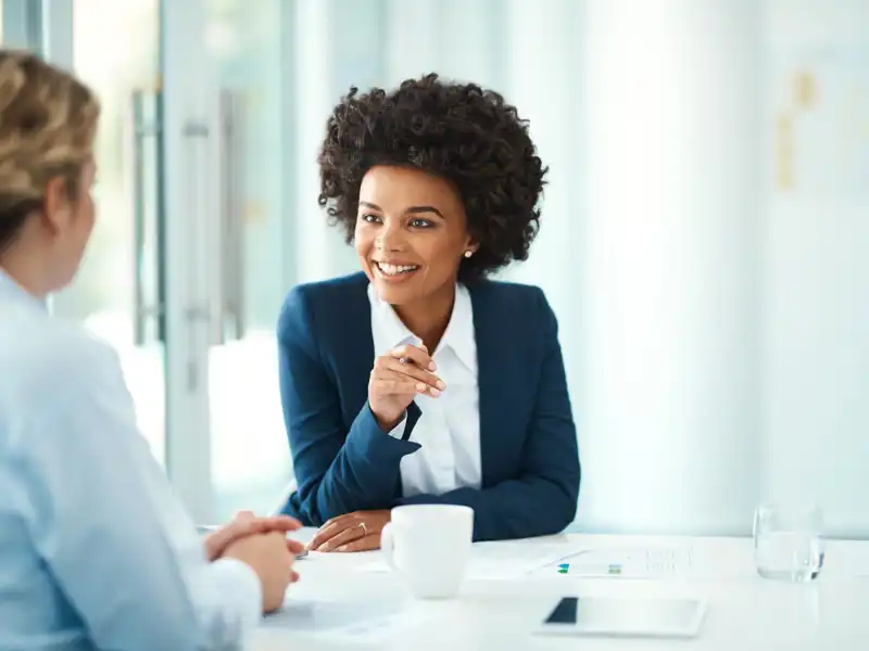 Two business women talking over coffee.