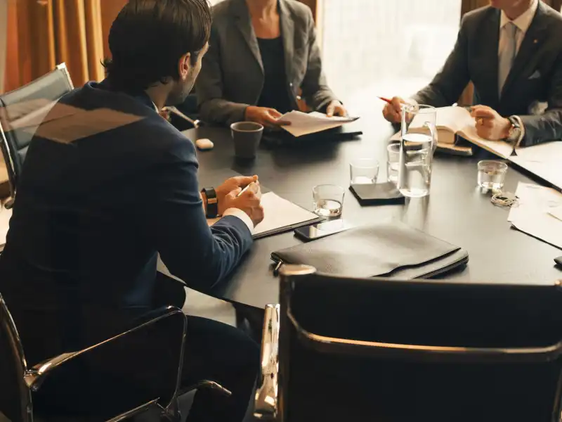 Group of business people sitting at a table talking.