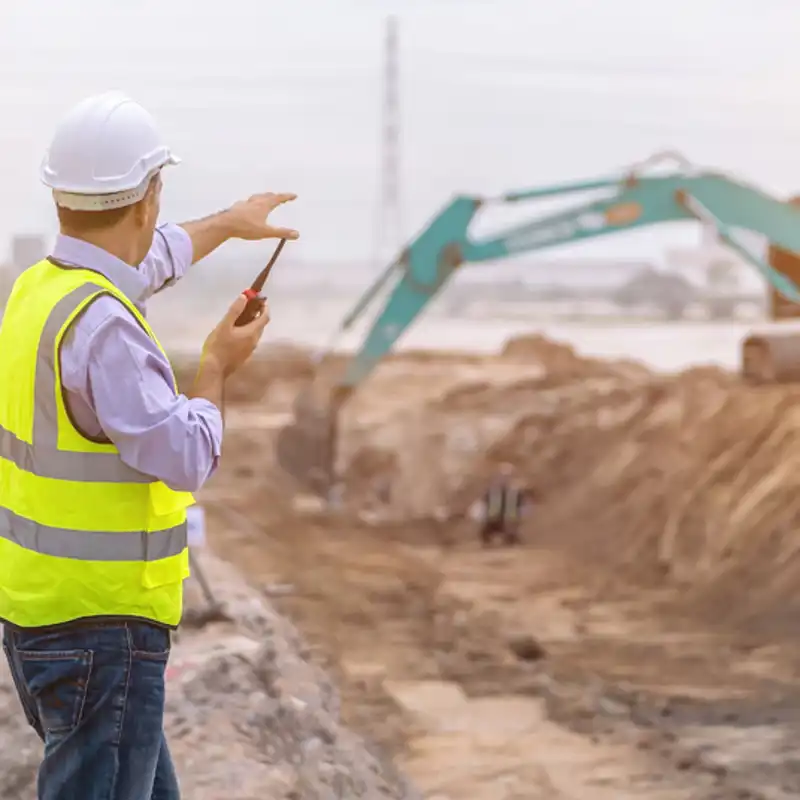 construction worker talking on a walkie talkie on a job site