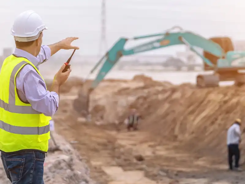 construction worker talking on a walkie talkie on a job site