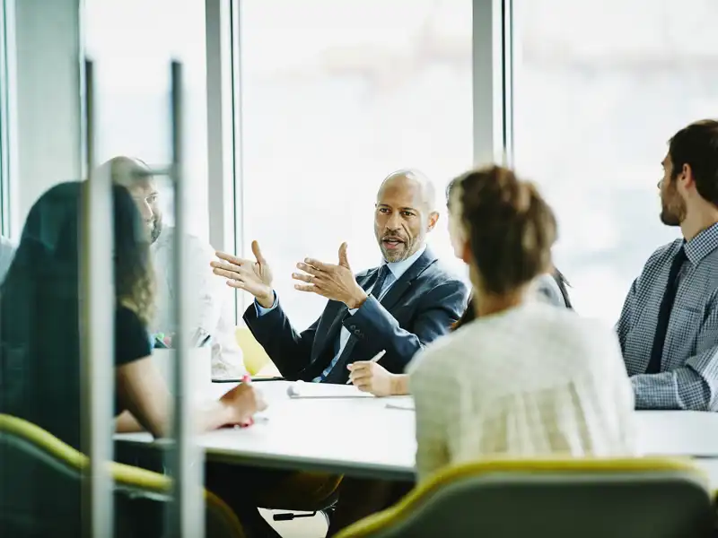 Business man speaking with colleagues in a meeting.