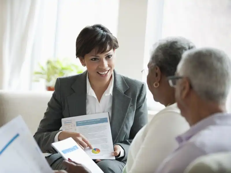 A woman explains a chart to an older couple