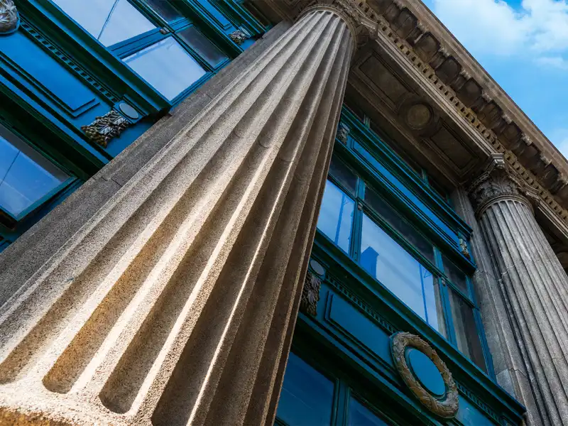 Street view of a large building with columns.
