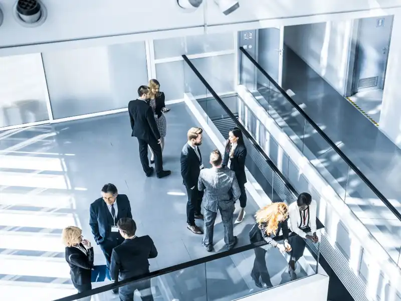 Professionals standing in groups talking