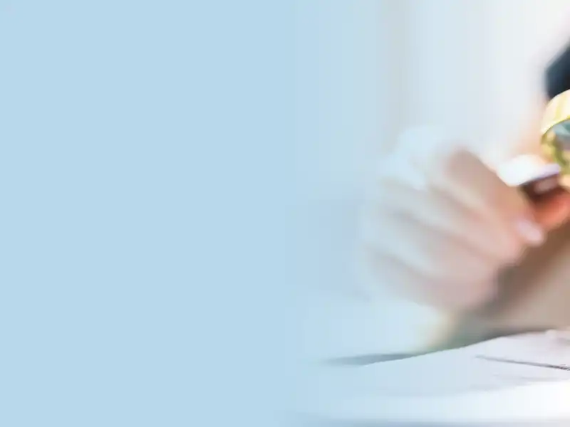 A person studies a document with a magnifying glass.