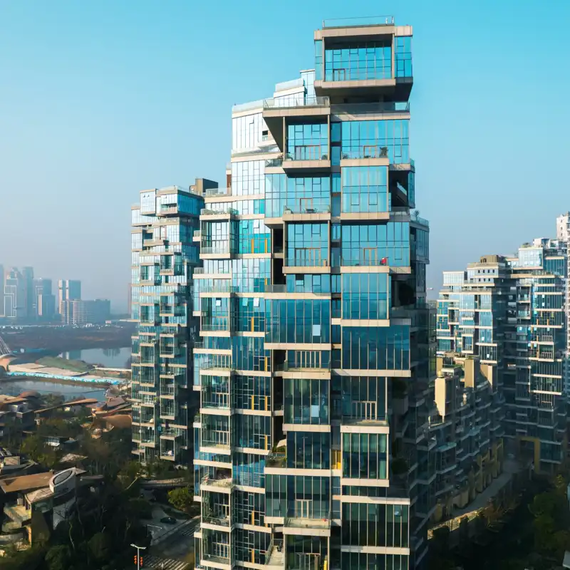 A modern architecture apartment building towers above a city skyline.