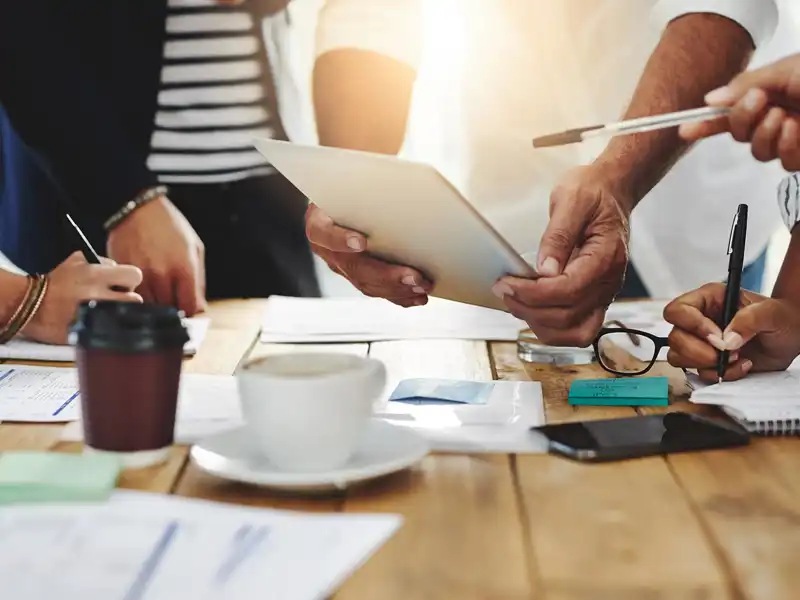 group of coworkers sitting around a table during a meeting