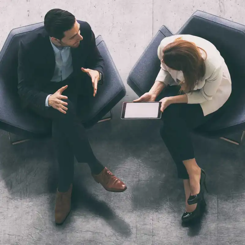 aerial view of two people sitting on chairs chatting