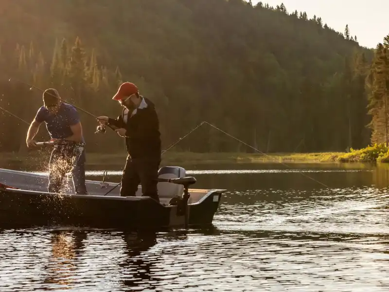 two men fishing on a lake in the early morning