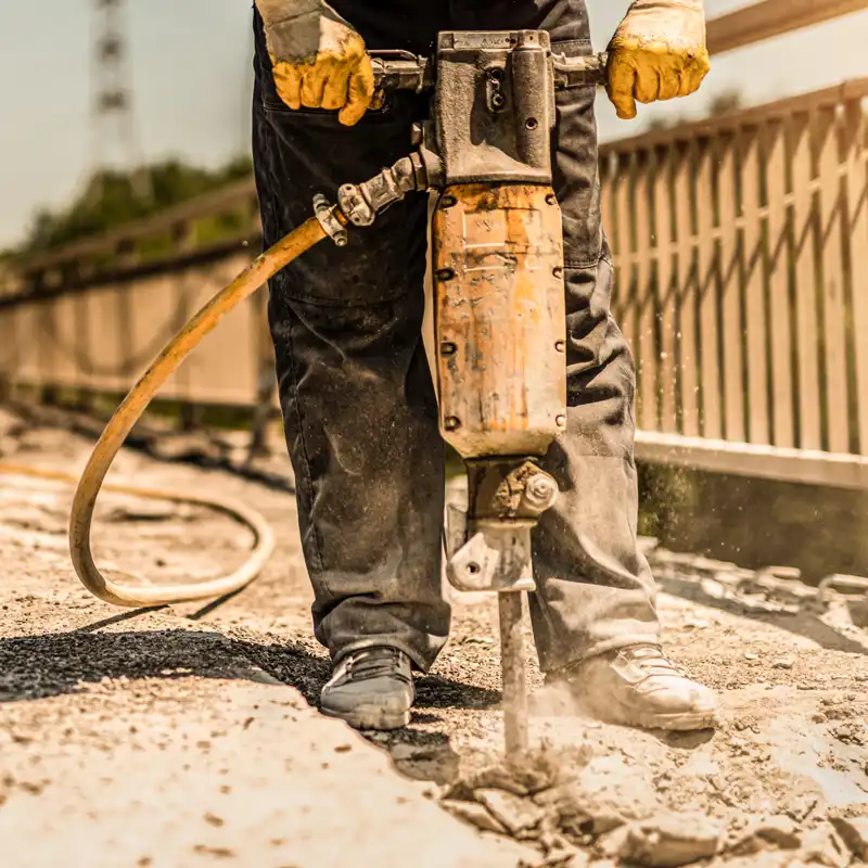 someone using a jackhammer during road construction