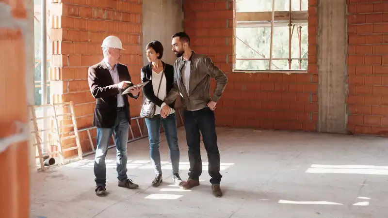 constructjon foreman going over building plans with clients