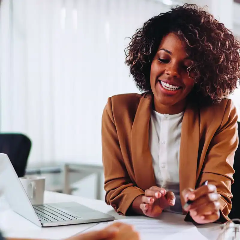 black woman speaking with an agent with papers and a laptop