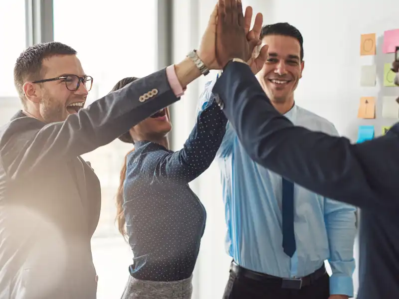 Office coworkers high fiving.