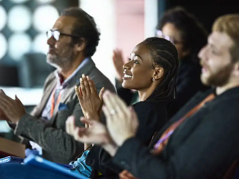 A group of professionals clapping after a presentation.