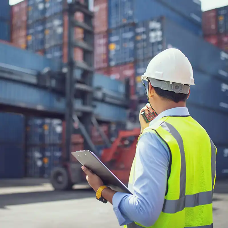 A dock worker carries a clipboard