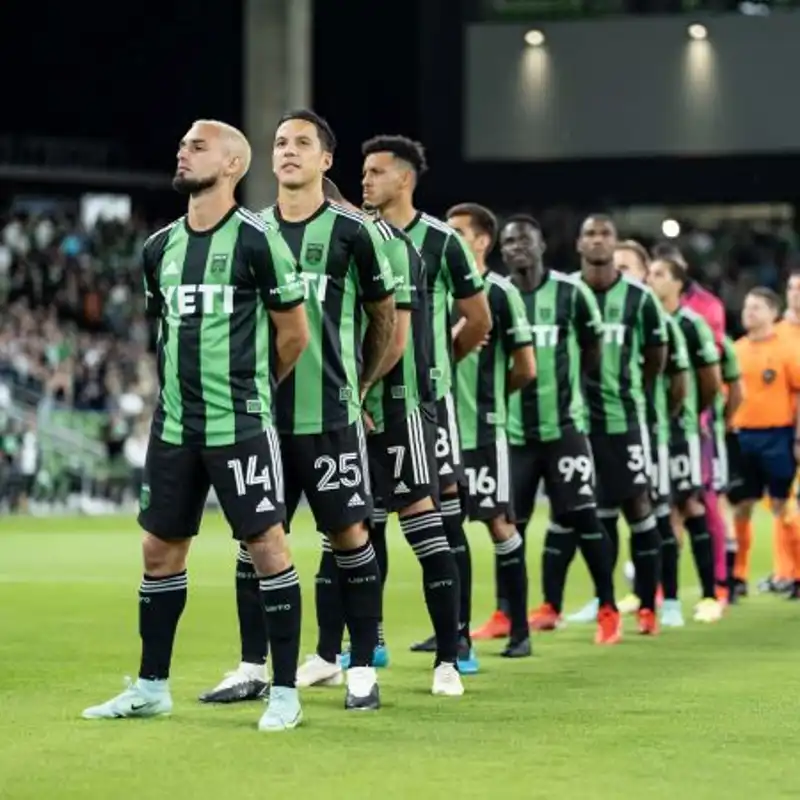 Austin FC players standing on a soccer field.